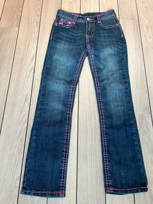 True Religion jeans - Jättefina True Religion-jeans säljes i nyskick.  Lågmidjade!  Storlek: 12, motsvarar 140/146 i svensk storlek.  Hör av för fler bilder 