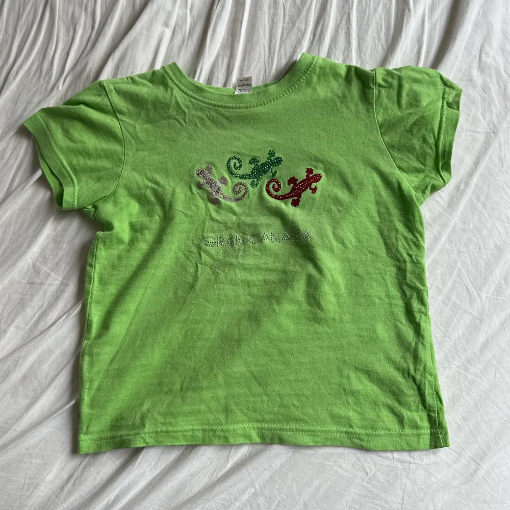 Jättesöt baby-tee med ödlor i strass. Bra skick men lite strass saknas (bild 3), inte märkbart dock! Barnstorlek 6 år men passar XS/S🌷💚🫶. T-shirts.