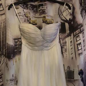 En vit strapless kläning som jag säljer för att den är för liten:D Använd ett fåtal gånger. Den har gummiband runt hela överdelen så att den inte åker ner så lätt. Storlek 32.