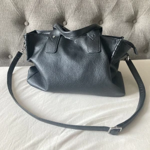 Svart läderväska - Säljer denna fina läderväskan! 💘💘 Köpt för 700kr och säljer för 200kr! Det rymmer mycket i den.