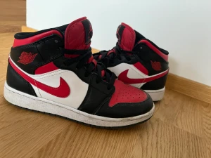 Fire red air jordans mid - Jag säljer dessa eftersom att de har börjat bli för små. De är i storlek 38, Jag har bara haft de sen i mars men skosnörena har blivit väldigt slitna. Därför sänker jag även priset lite extra mycket då orginal priset  är 2000kr. Skosnörena går att knyta.