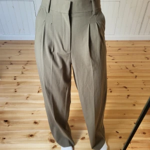 Bruna kostymbyxor - Brungråa kostymbyxor från Zara. Vida ben. Köpte de för 450 kr. Midjan är 65 cm och ytterbenslängden är 110 och innerbenslängden är 85cm. Jag är 173 cm och de passar mig i längden  