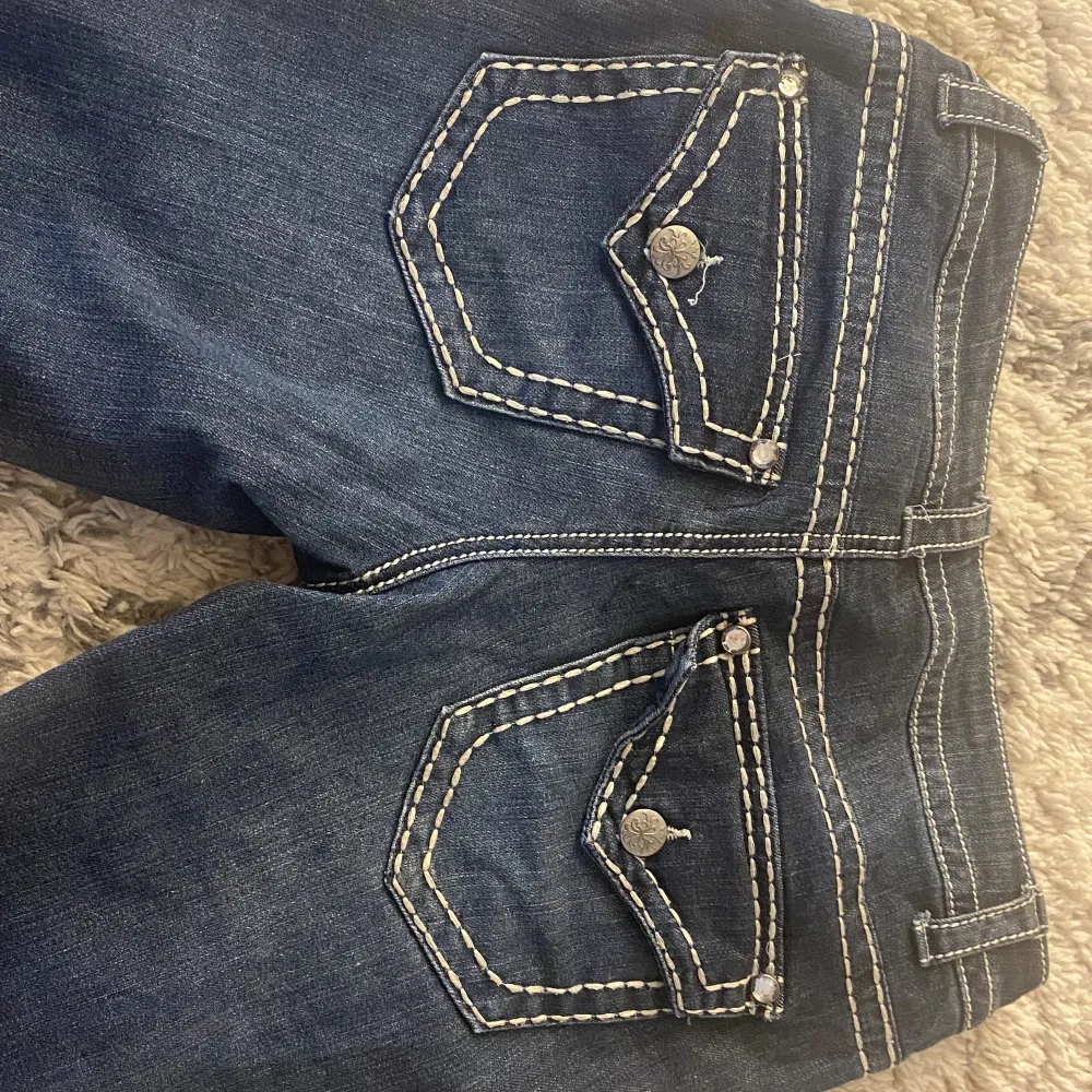 Lågmidjade jeans med coola fickor och detaljer. True religion inspirerade. Står ingen storlek men uppskattar till nåt mellan 27-28.  Köpare står för frakten. Hör av er vid frågor eller intresse🙏🏼. Jeans & Byxor.
