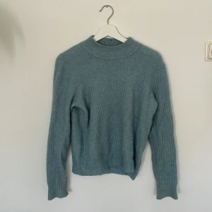 Stickad tröja  - Ljus blå stickad tröjor.  Har lite noppror som går att ta bort. 34% alpacka  29% Wool