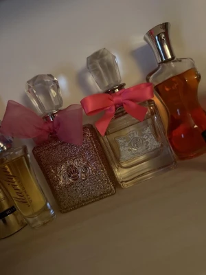 Juciy couture parfymer - 1 parfym är full (den genomskinliga med rosa rosett), dom andra två är tomma och bara stått dom prylnad. 500:-  