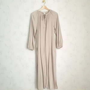 Beige lång klännig - 🧁FÖRST TILL KVARN!🧁 En fin luftig beige klänning från h&m. Har slits vid sidorna och knytband detalj runt halsen som man kan knyta till en söt rosett🤍