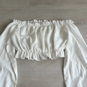 Blus off Shoulder  - Jätte fin vit off Shoulder blus men långa armar. Band i tröjan för att få tröjan sitta och inte lätt åka ner vilket gör att tröjan sitter perfekt! Inte genomskinligt och super fin ute kväll Top!❤️