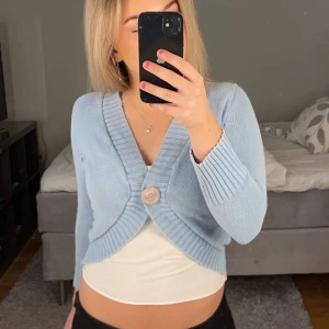 Kroppad kofta - En ljus blå kroppad kofta med en knapp. Braskick, jätte söt