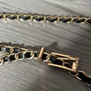 Skärp - Svart och gulligt skärp. Bra skick. Den är 107cm lång.