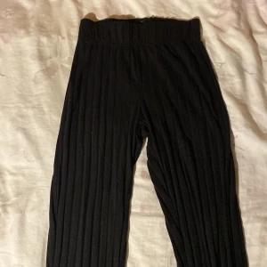 Ett par svarta utsvängda byxor - Dessa byxor är i ett mjukt material. De är ganska sköna och jag knappt blivit använda.