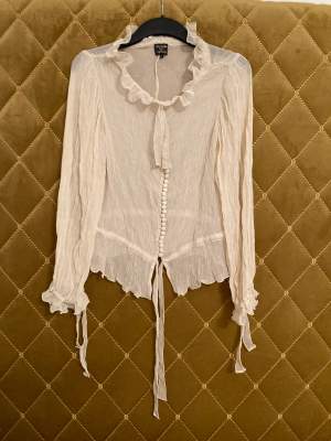 Blus i 100% silke från topshop i samarbete med Kate Moss, genomskinlig, beige. Strl S (väldigt lite i storleken, mer som XS) aldrig använd men säljer billigt eftersom ugglorna som håller knapparna är små gummiband och några av dom har töjts ut (pga tiden)