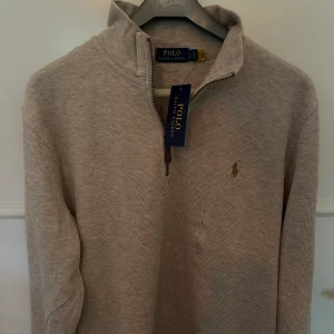 Polo Ralph Lauren half zip - Polo Ralph Lauren half zip i storlek L. Beige färg med brun logga. Helt Ny