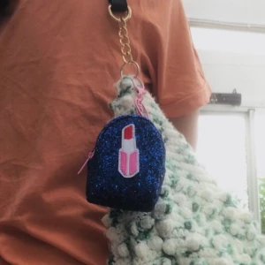 Liten extra väska - Bra att förvara bla läppstift 💄 (som bilden på väskan visar) nycklar eller kanske sudd ✏️. Vad som helst funkar. Väskan är väldigt liten och praktisk, blå glittrig och har rosa dragkedja för att öppna den