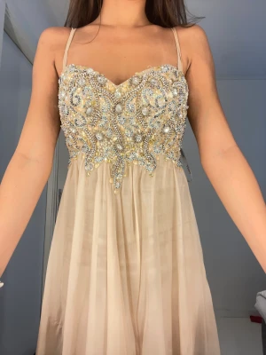 Balklänning/festklänning  - Märke: Jovani  St: 36  Guld färg, lång, broderad och prinsess passform.  Har använt den endast 1 gång.  Ursprungliga pris var: 2500 kr