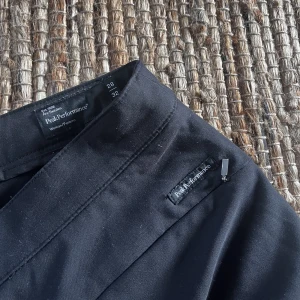 Golfbyxor - Snygga svarta byxor från Peak Performance golfkollektion. Fina att användas även om man inte spelar golf. Två sidfickor och diskret dragkedja nertill. Skön passform. 