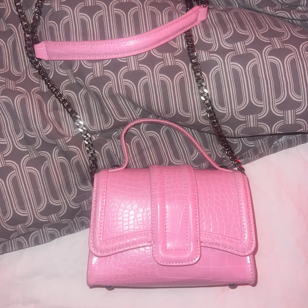 Axelrem väska från Zara i barbie rosa. Aldrig använd.  Silver kedja. Köpt för 400!. Väskor.