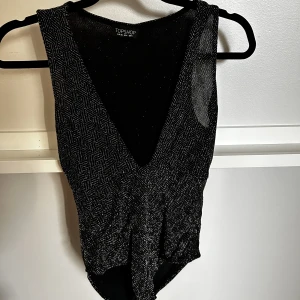 Glitter body från zara - Glittrig body med djup v-ringning köpt på second hand, jag har aldrig använt den.