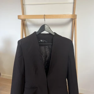 Svart kavaj - Stil och elegans går hand i hand med vår svarta kavaj. Denna tidlösa klassiker är ett måste i varje garderob. Vår svarta kavaj är inte använd och den ger dig den perfekta passformen.