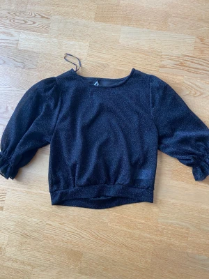 Fest topp - Säljer denna glittriga t-shirt från bik bok. Lappen sitter löst men tänker att det inte gör så mycket. Storlek xs. Säljer för 60 kr+frakt.