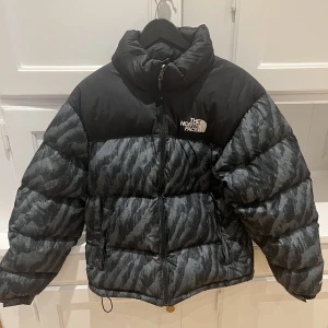 THE NORTH FACE Vinterjacka - Varm vinterjacka i mycket gott skick. Mindre lagning via skräddare, höger arm, syns knappt se bild.  Inköpt 2022 på THE NORTH FACE butiken på Kungsgatan.  Modell: Nuptse Färg: Print green Storlek: M Herr 