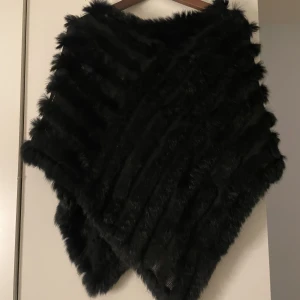 Svart pälsponcho - Svart pälsponcho från hollies i bra skick