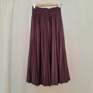 Fin kjol från Vila. Tyvärr för liten för mig (har 73 cm i midja). Tvättad och använd endast en gång.   Strl: S sann till storlek.  Material: glansigt Färg: vinröd  Inköpspris: 379 kr  