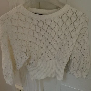Stickad vit tröja - En stickad vid tröja, lite kortare nästa som en magtröja. Är i storlek XS och bara använd en gång