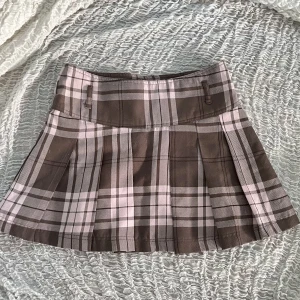 Rutig minikjol - En ljusbrun och babyrosa minikjol som är i fint skick. Jag hade så gärna behållt den men jag växte tyvärr ur den. Skriv gärna i kommentarerna eller direkt till mig om du undrar något eller vill ha fler bilder!<3
