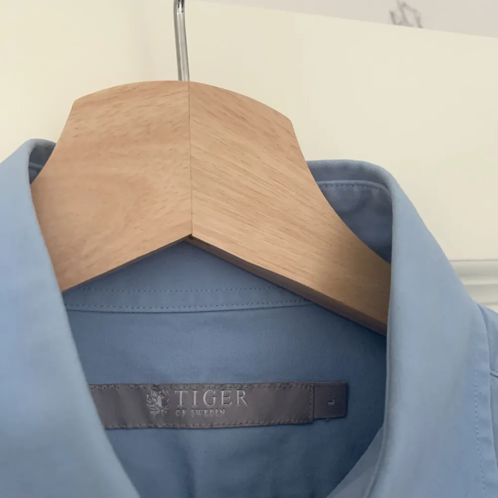 Skjorta från Tiger of Sweden i ljusblå färg. Lätt färgskiftning i armhåla enligt bild. Figursydd.. Skjortor.