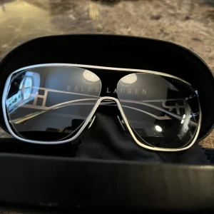 Ralph Lauren solglasögon  - Märke: Ralph Lauren Skick: Väldigt bra. Inga Defekter. Lådan solglasögonen kom i har lite små märken(inget synligt). Nypris: 1600kr  Kan mötas upp i Stockholmsområdet.