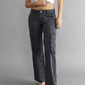 Low Waist Cargo Jeans - Supersnygga mörkgråa cargo jeans med låg midja. Använda en gång då de inte passade mig. Nyskick!
