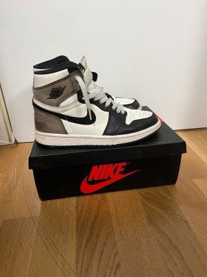 Jordan 1 High Mocha - Ett par Jordan 1 High Mochas i använt skick. Kommer med låda och kvitto från StockX. Skickas spårbart och dubbelboxat med PostNord