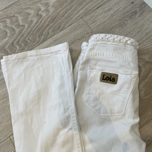 Lågmidjade jeans - Vita lågmidjade utsvängda jeans ifrån Lois. Frina detaljer från midjan. I bra skick! Säljer då dom är för små på mig som har storlek 36 i jeans😊