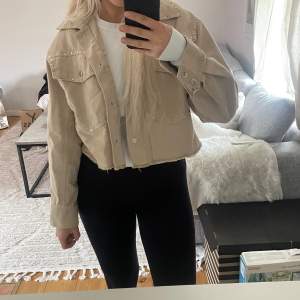 Beige jeansjacka med nitar från pull and bear i storlek S, väldigt sparsamt använd.