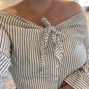 Randig off-shoulder skjorta - Randig blå/vit randig off shoulder skjorta i storlek 42. Använd ett fåtal gånger så i gott skick. Ingen stretch!