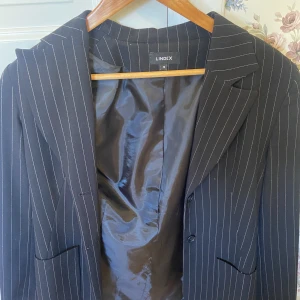 Svart randig kavaj/blazer - Fin blazer från Lindex i storlek 36. Sitter bra i längd på mig som är ca 166. Säljer då den inte används mycket!