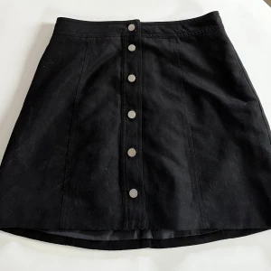 Kjol - Svart kjol med knappar.