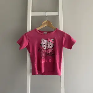 En croppad hello Kitty t - shirt. Den är ganska stretchig och i väldigt bra skick.  Det går bra att klicka på köp nu på en gång. 