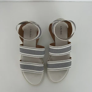 blå vita sandaler  - blå vita sandaler från &other stories. små tecken på användning därav det billiga priset. så fina både till jeans men också klänning o kjolar. nypris 590kr o stlk 37.