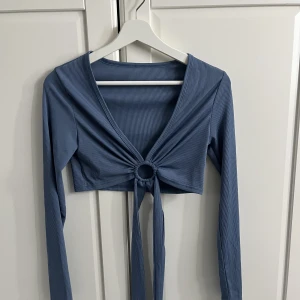 Långärmad - Fin blå långärmad som man kan knyta på olika sätt runt sig, används ej och därför säljs, storleken står ej men passar mig som är M men skulle nog även passa S och kanske L💕