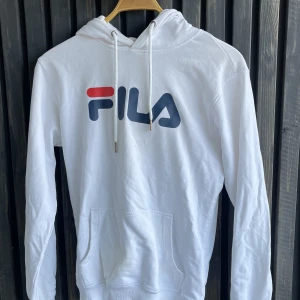 FILA hoodie - Sparsamt använd hoodie från FILA. Storlek XS. Har en liten fläck som visas på bilden, går kanske att tvätta bort.   Hämtas i Lund eller skickas om köparen står för frakten. 