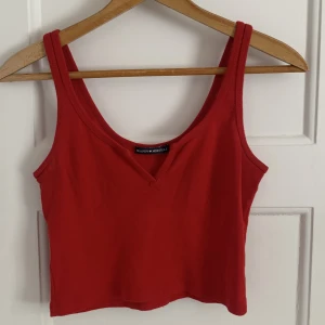 Röd topp med fin detalj  - Säljer denna väldigt gulliga toppen från Brandy Melville då jag tyvärr inte använder den längre väldigt fint skick och skulle säga att den passar allt mellan xs-L. Fint skick.