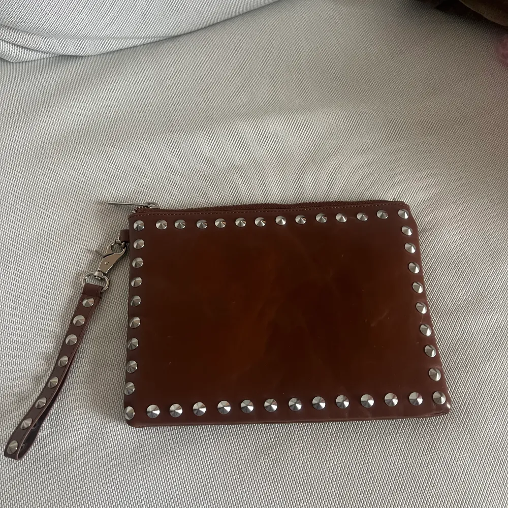Skitball clutch med silvernitar i en vinröd/brun färg från Gina Tricot. . Väskor.