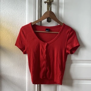 Topp - Rödorange topp från Gina med knappar framtill. 