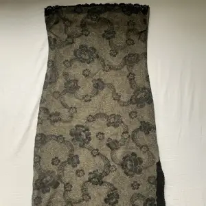 Superfin Veromoda klänning med kanter i spets och slits vid benet. Relativt kort. Går att använda som både klänning och kjol. Grön/brun färg med svarta detaljer.