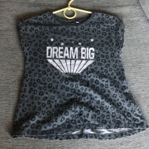 T-shirt - Sälja den här fina t-shirten i färg mörk grå och svart och vit storlek 130 från lager 157