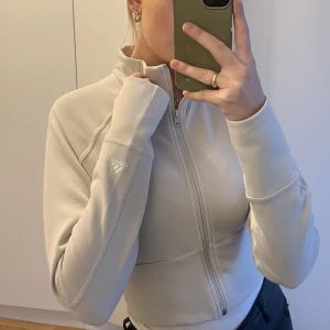 Adidas träningströja - Croppad träningströja från adidas , biege i strl S. Sparsamt använd 