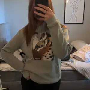 En grå The cool elephant hoddie med tryck av en tiger.