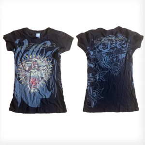 Ed Hardy T-shirt - Ed hardy t-shirt i strechigt material med rhinestones , däremot har många stenar låsnats från tröjan (bild 2) storlek S .  Du har möjlighet att hämta upp den om du inte vill ha den postad till dig<3