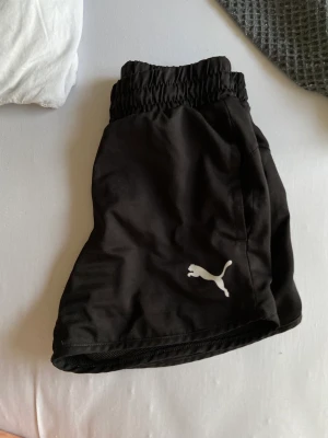 TRÄNINGS SHORTS - PUMA! Träningsshort, perfekt till fotboll och sport. Eller bara i vardagen! Sitter snyggt och tajt på, OBS! liten i storlek. Använt ett fåtal gånger men i bra och nyskick. Säljs då den är för liten för mig. Storlek 152, men passade mig som var en XXS/XS